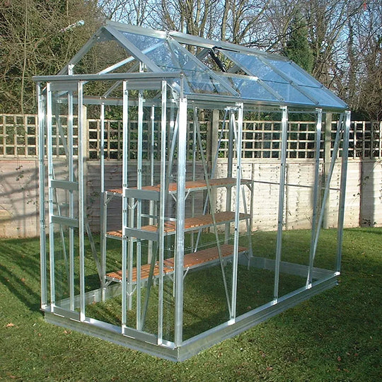 Cottage 8 greenhouse in aluminum finish with slatted staging, installed on grass 